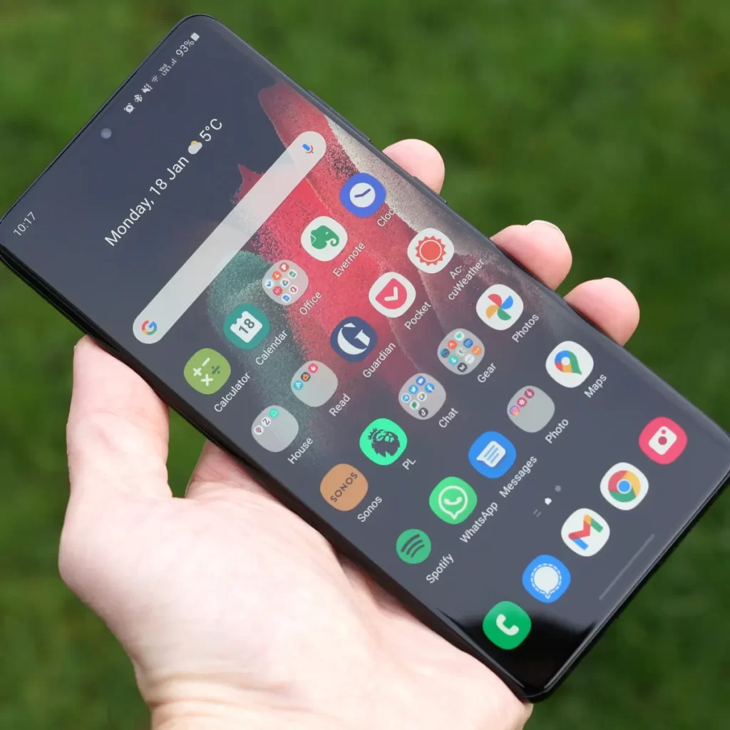 Person holding an Android smartphone with apps on the home screen